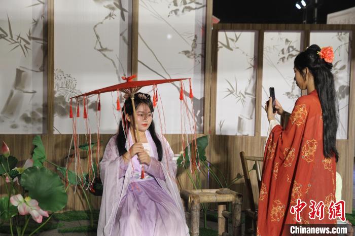 圖為市民游客在海口古風(fēng)市集體驗(yàn)漢服，拍照打卡?！?jiān)潞?攝