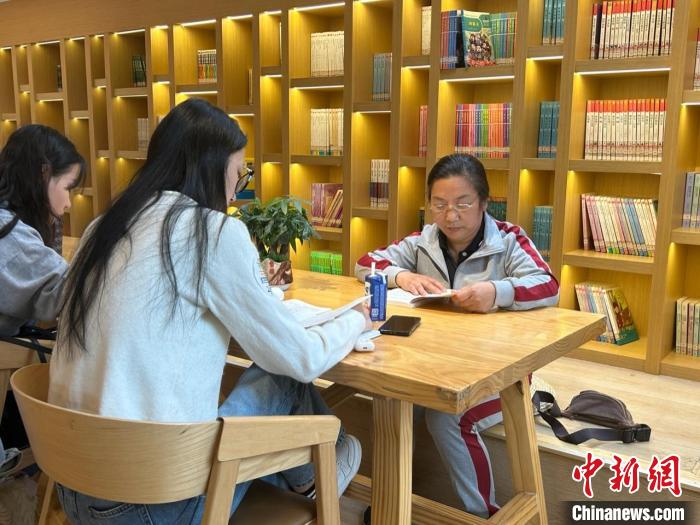 圖為22日，左桂香(右一)在新建區(qū)抱樸書屋閱讀。　朱瑩 攝