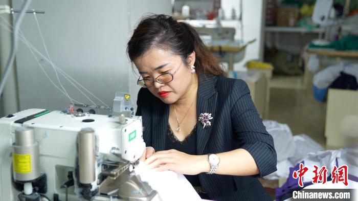 圖為李王花上機(jī)操作縫紉服裝?！￡愑⑶?攝