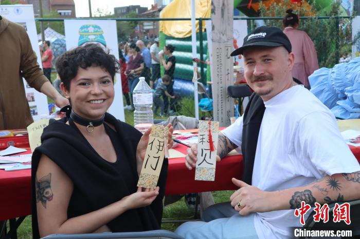 當(dāng)?shù)孛癖娫跐h字體驗工作坊展示自己手寫的中文名書簽?！◆斻肟鬃訉W(xué)院供圖