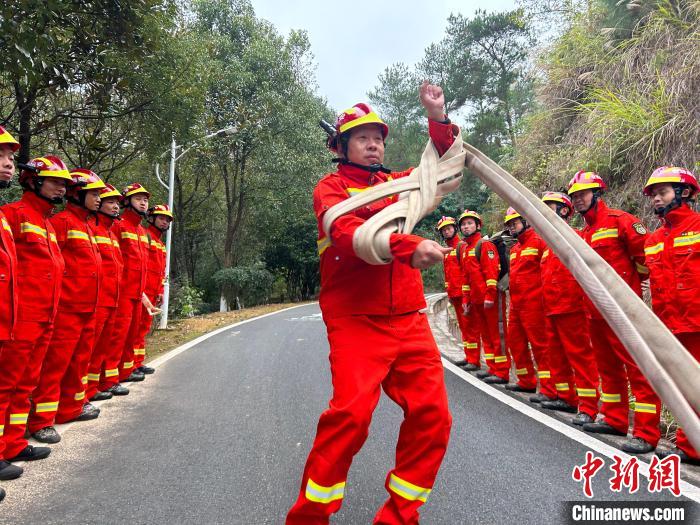 鐘曉金正在向隊(duì)員們展示如何快速回收消防水帶?！《拍弦?攝