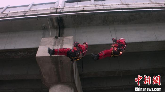 圖為指戰(zhàn)員正在進(jìn)行快速橋降?！×种ナ猩窒乐ш牴﹫D