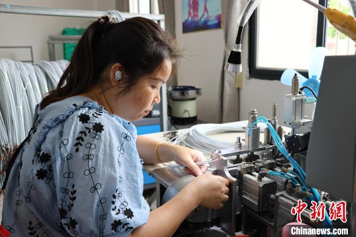 車頭村本地工人正在給數(shù)據(jù)線焊錫?！⒀┤?攝