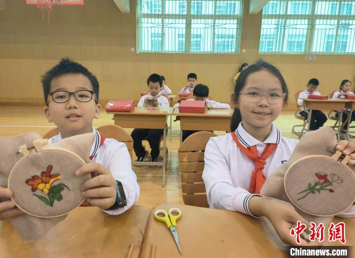 長沙市芙蓉區(qū)育英學(xué)校的學(xué)生展示湘繡作品?！√菩∏?攝