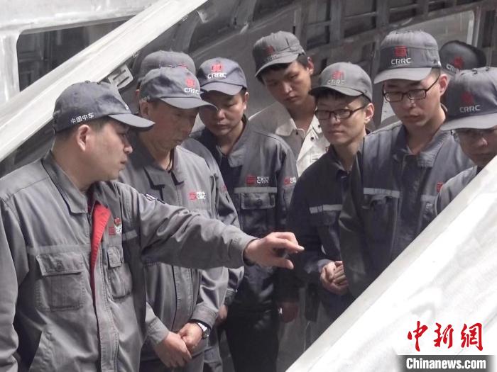 周晶輝正在為徒弟們講解司機室前窗框平度控制。　受訪者供圖