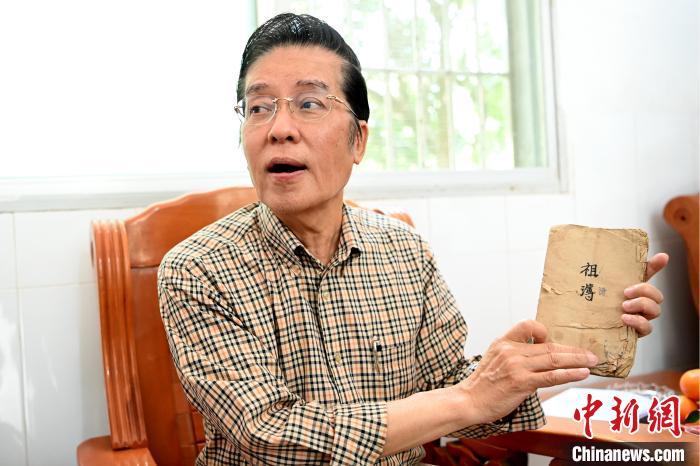 張榮恭手中拿著北坑村族親收藏的族譜與族親交流?！埥鸫?攝