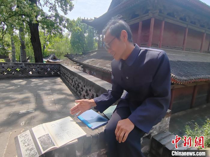 圖為王永先向記者介紹其發(fā)表在雜志期刊上的文章?！「哂昵?攝