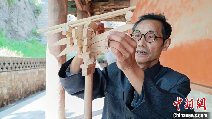 圖為王永先和他的自制斗拱模型。　受訪者供圖