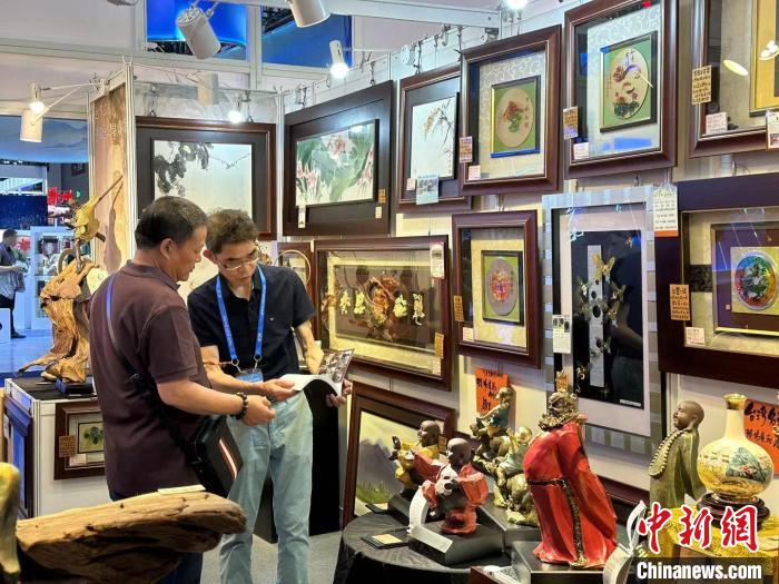 葉國鐘(右)向觀展者介紹臺(tái)灣藝術(shù)品?！》絺ケ?攝