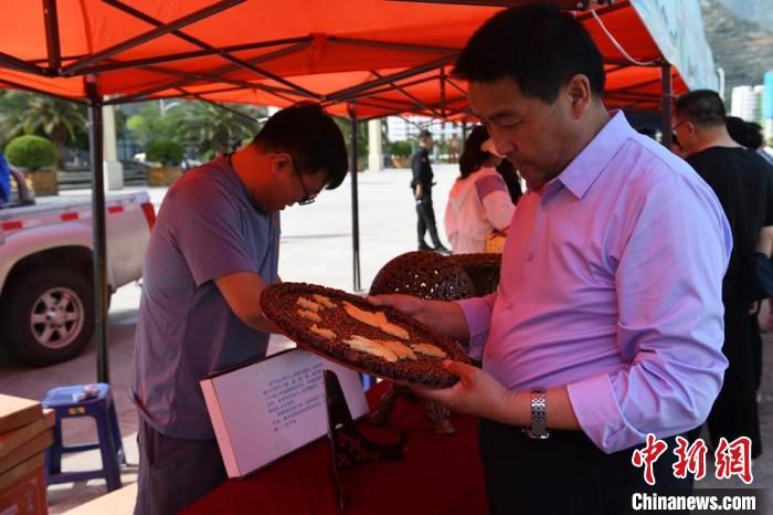 圖為游客參觀非遺工坊?！〈魑牟?攝