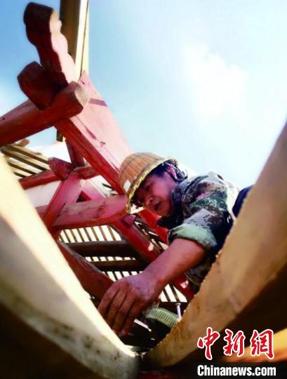 資料圖為造橋師傅進(jìn)行挑梁安裝。　龔健 攝