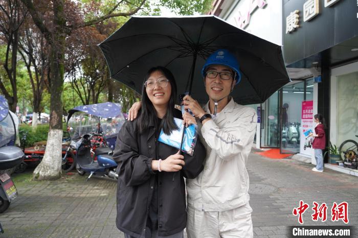 圖為楊功書(右一)準(zhǔn)備送女兒進(jìn)考場?！“惨?攝