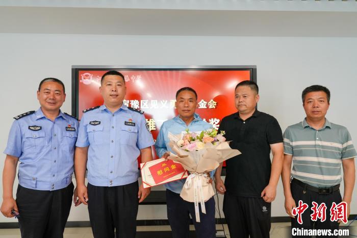 宿遷市公安局宿豫分局和宿豫區(qū)見義勇為基金會(huì)為丁成闖送上見義勇為表彰證書和慰問金?！∷拊^(qū)委宣傳部供圖
