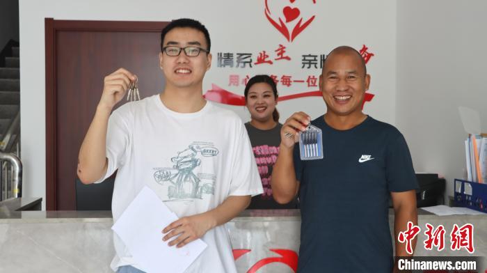 圖為剛剛拿到鑰匙的青年?！∴崢淦?攝