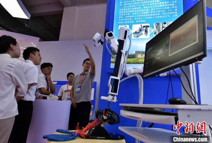 圖為參觀者在展會上了解醫(yī)用手術設備?！埍?攝