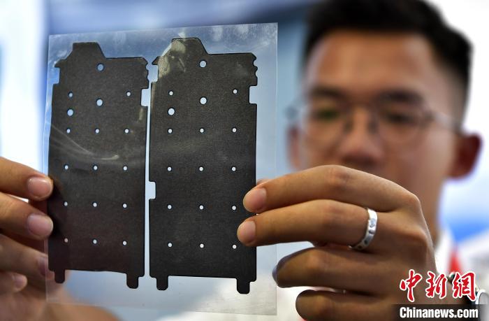 圖為展會工作人員在展示石墨烯導熱膜?！埍?攝