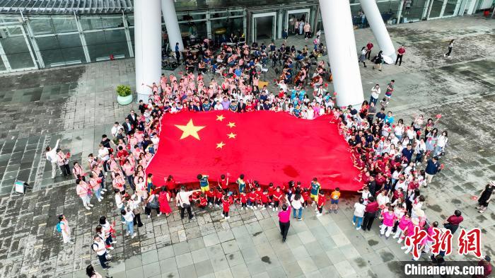 出席快閃音樂會(huì)人士拉起五星紅旗合影?！≈鬓k方 攝