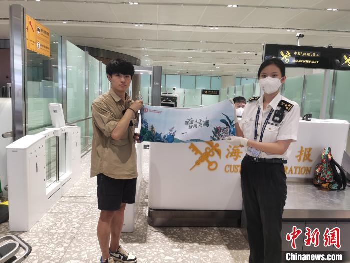 圖為大興機(jī)場(chǎng)海關(guān)對(duì)入境旅客進(jìn)行禁毒知識(shí)宣傳?！±钌袧?攝