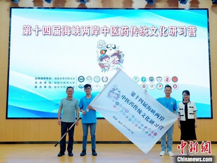 共青團(tuán)福建省委副書(shū)記吳雪(右一)、福建中醫(yī)藥大學(xué)黨委副書(shū)記林羽(左一)為兩岸學(xué)生代表頒授營(yíng)旗?！≡S燁婷 攝