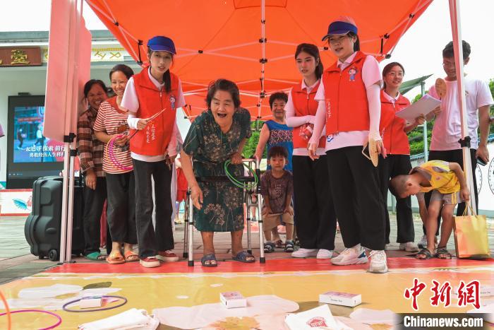 圖為學(xué)子們與村民共同體驗(yàn)套圈讀順口溜游戲?！￡愐圾Q 攝