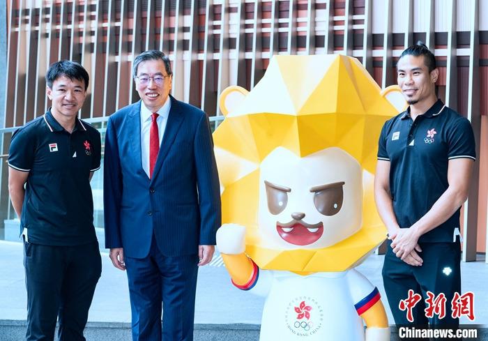 7月5日，香港立法會(huì)主席梁君彥在立法會(huì)綜合大樓出席為即將出征杭州2022年第19屆亞運(yùn)會(huì)的中國香港代表團(tuán)加油打氣活動(dòng)。圖為梁君彥(左二)與香港前自行車運(yùn)動(dòng)員黃金寶(左一)、前空手道運(yùn)動(dòng)員李嘉維(右一)在本屆中國香港代表團(tuán)吉祥物獅子“堅(jiān)仔”旁合影。 <a target='_blank' href='/'>中新社</a>記者 侯宇 攝