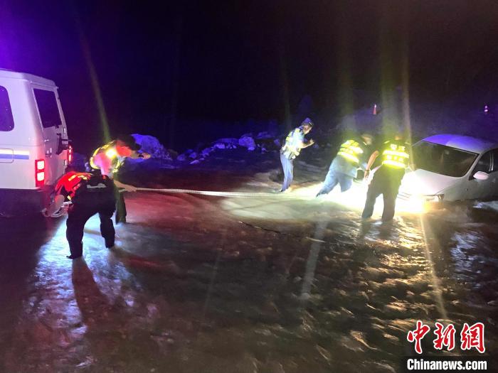 圖為民警幫助車輛安裝救援繩。　張力 攝