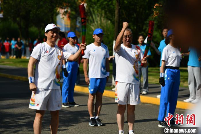 樊建川(右)與廖昌永(左)在成都大運會火炬?zhèn)鬟f現(xiàn)場?！埨?攝