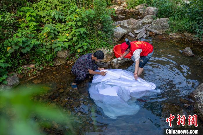 老人和義工一起洗幕布。　章毅 攝