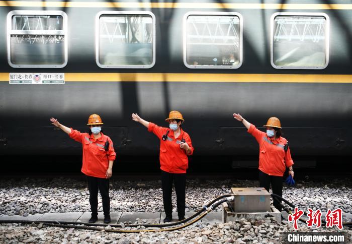 7月6日，在南昌車站，為到達的列車加滿清水后，上水工胡飛英和工友們比劃手勢準備通過軌道上站臺?！『鷩?攝