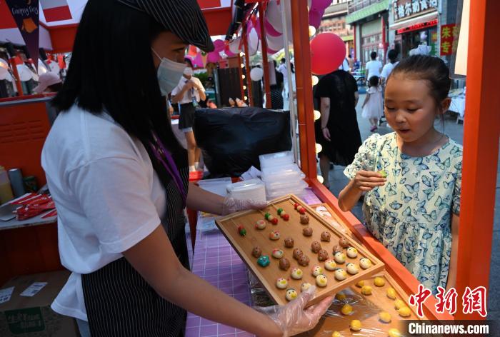 內蒙古呼和浩特市，小朋友品嘗泰國露楚。　劉文華 攝