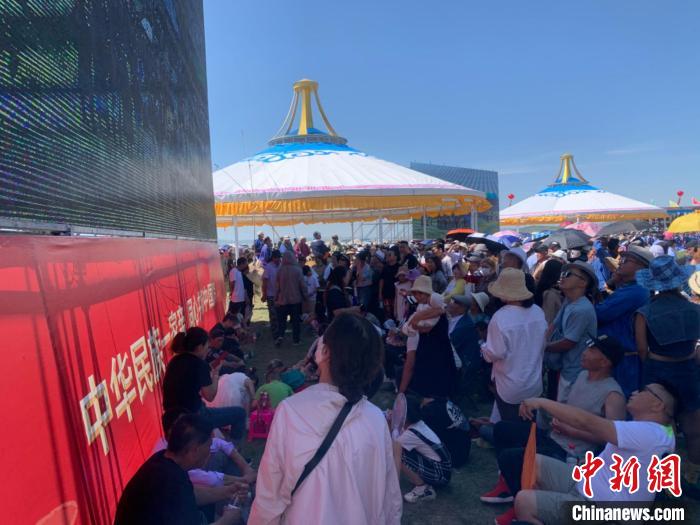 圖為沒有擠進座位席的人們，在會場一側(cè)的大屏幕下觀看演出。　奧藍 攝