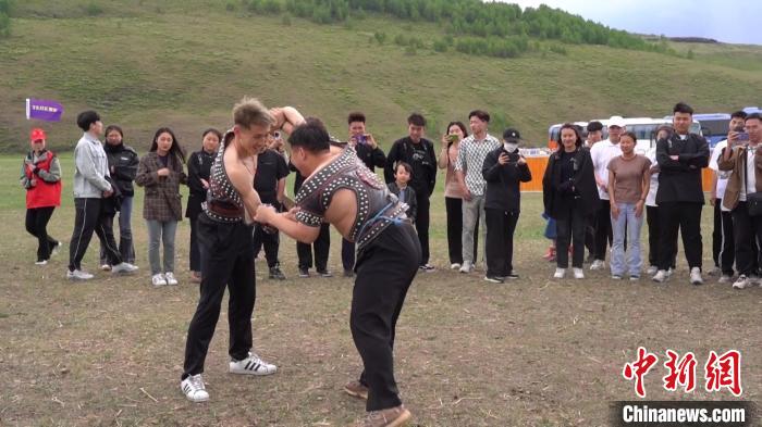 圖為大學(xué)生體驗(yàn)傳統(tǒng)摔跤?！∪雇醒?攝