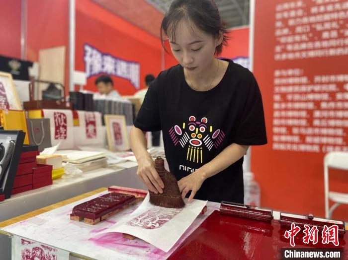 7月14日，周口華威民俗文化博物苑的講解員杜奧杰在文博會(huì)現(xiàn)場(chǎng)展示拓印。中新社記者張瑋攝