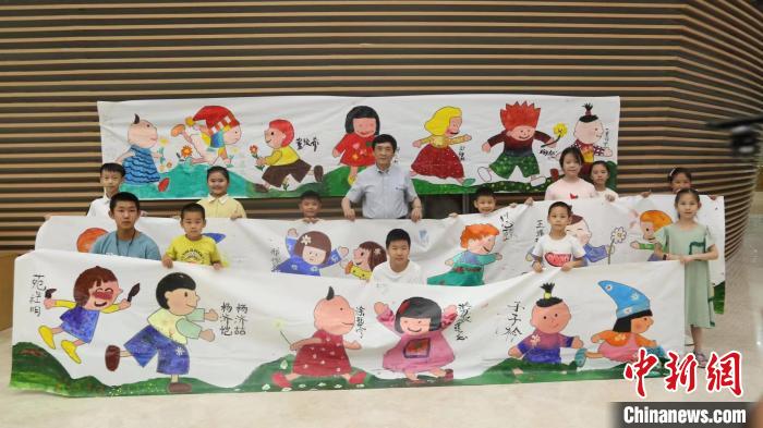 曹文軒現(xiàn)場和孩子們合影?！∶魈斐霭嫔绻﹫D