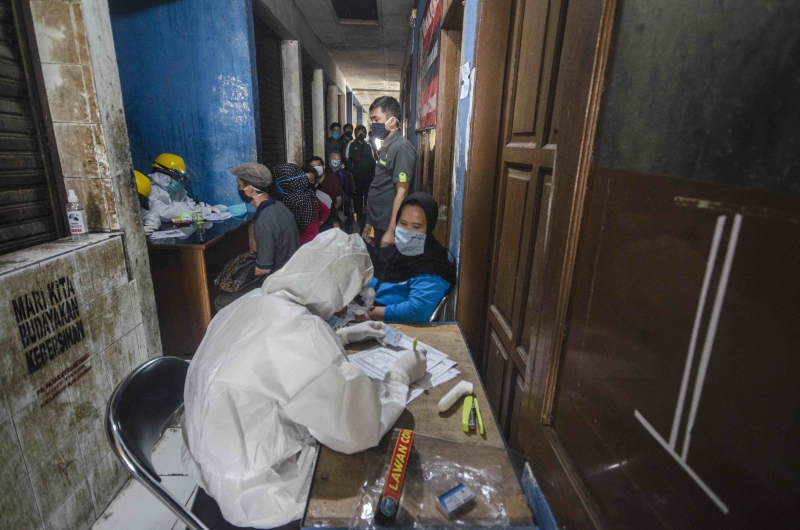 △2020年6月11日，醫(yī)務人員在印度尼西亞萬隆為人們做檢測。