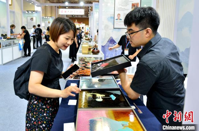 圖為臺灣大漆文創(chuàng)品吸引參觀者。呂明 攝