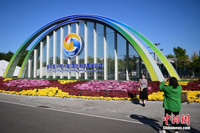 10月15日，北京，工作人員在國家會議中心外的第三屆“一帶一路”國際合作高峰論壇景觀布置前拍照留念。當日，位于國家會議中心的第三屆“一帶一路”國際合作高峰論壇新聞中心啟動試運行。據(jù)悉，第三屆“一帶一路”國際合作高峰論壇將于10月17日至18日在北京舉行。<a target='_blank' href='/'>中新社</a>記者 田雨昊 攝