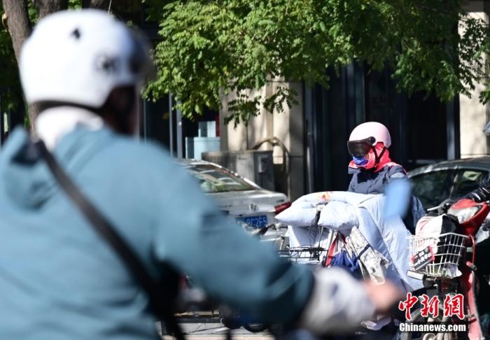 石家莊街頭，市民紛紛穿上厚厚的外套“捂”裝前行。 <a target='_blank' href='/'>中新社</a>記者 翟羽佳 攝