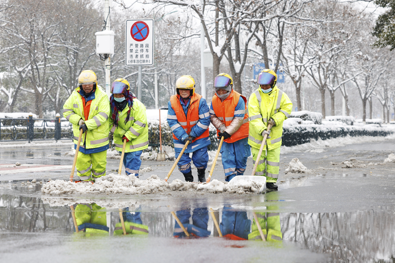 2月4日，在江蘇省宿遷市泗洪縣泗州大街，工作人員在清掃路面積雪。（圖源：新華社）