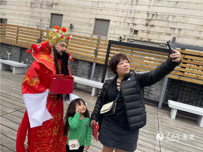 圖為送出吉祥如意的財(cái)神與游客合影。人民網(wǎng)記者 富子梅攝
