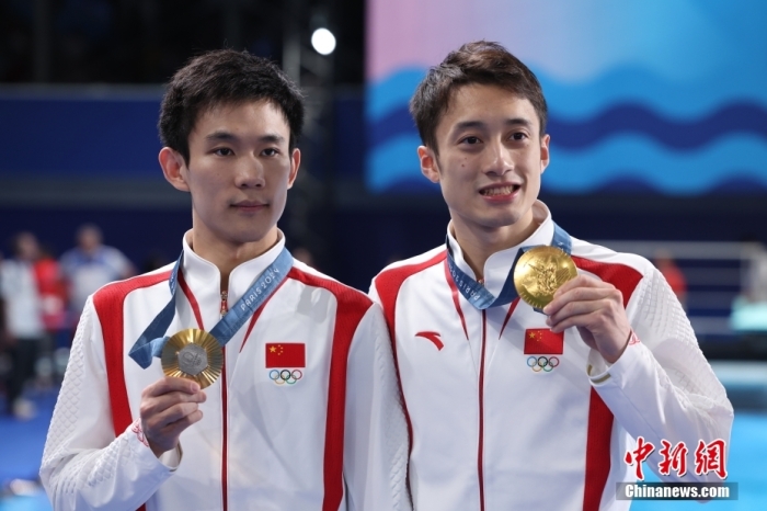 當?shù)貢r間7月29日，在巴黎奧運會跳水男子雙人十米臺決賽中，中國選手練俊杰/楊昊奪得金牌。圖為練俊杰(右)/楊昊在頒獎儀式上。<a target='_blank' href='/'>中新社</a>記者 富田 攝