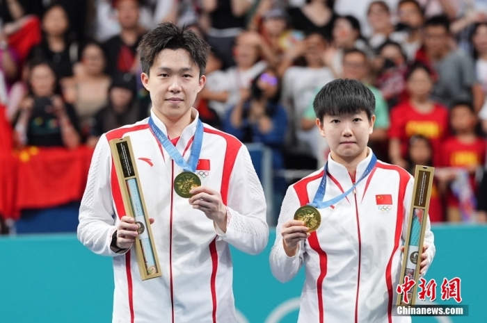 當(dāng)?shù)貢r間7月30日，在巴黎奧運會乒乓球混合雙打決賽中，中國組合王楚欽/孫穎莎以4比2戰(zhàn)勝朝鮮組合李正植/金琴英，為中國乒乓球隊奪得本屆奧運會乒乓球項目首金，同時這也是中國乒乓球隊在混雙項目上的奧運首金。圖為王楚欽(左)和孫穎莎在頒獎儀式上。<a target='_blank' href='/'>中新社</a>記者 趙文宇 攝
