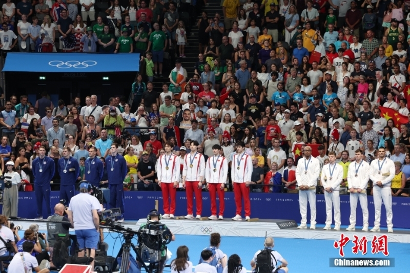 當(dāng)?shù)貢r間8月4日，在巴黎奧運會游泳項目男子4x100米混合泳接力決賽中，由徐嘉余、覃海洋、孫佳俊、潘展樂組成的中國隊奪得金牌。圖為中國隊（中）在頒獎儀式上。 
