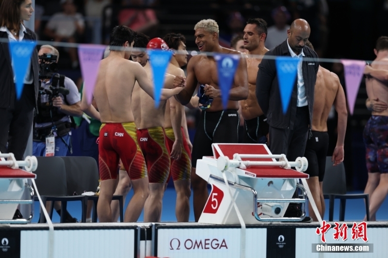 當(dāng)?shù)貢r間8月4日，在巴黎奧運會游泳項目男子4x100米混合泳接力決賽中，由徐嘉余、覃海洋、孫佳俊、潘展樂組成的中國隊奪得金牌。圖為場上運動員相互致意。