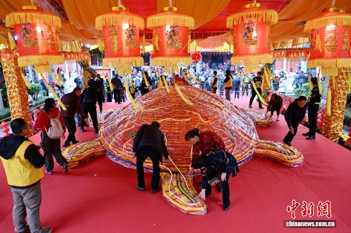 圖為民眾摸“米龜”祈福。中新社記者 呂明 攝